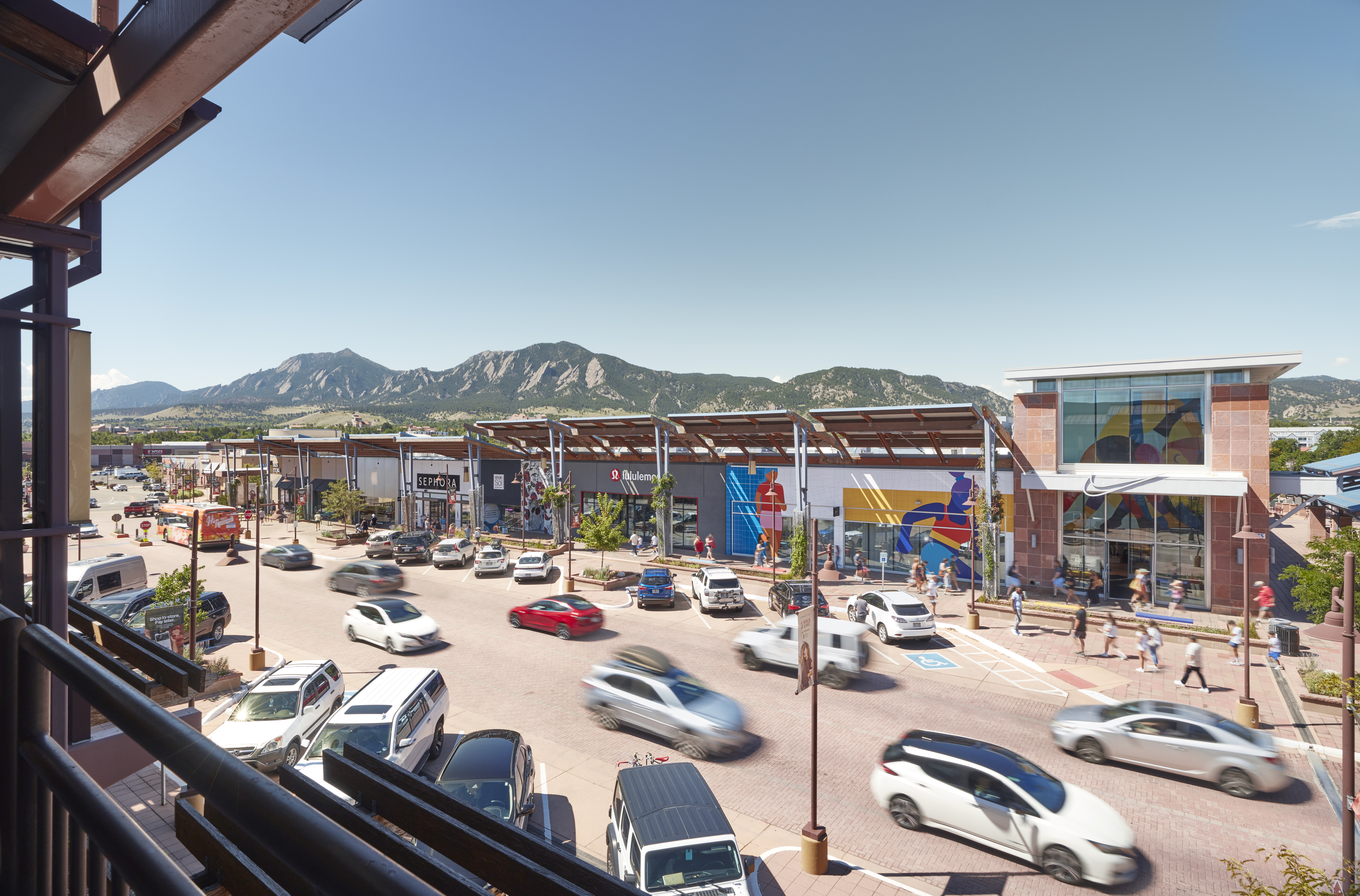 Car traffic on a mall road and mountain views.